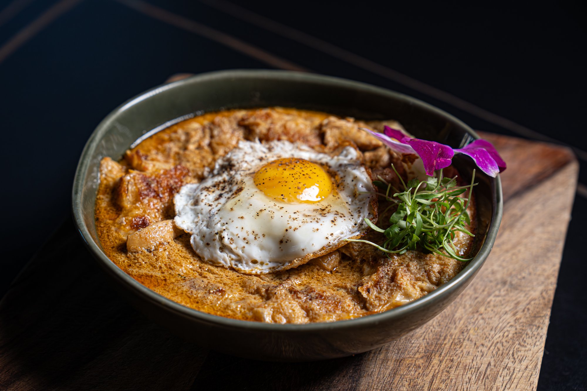 Chicken chatti parotta finished tableside in a clay pot